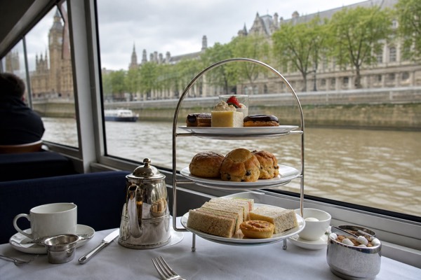 Afternoon tea stand with scones and sandwiches on a daytime Thames cruise