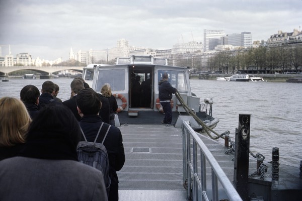 River boat pulling in to a central London pier with passengers waiting to board