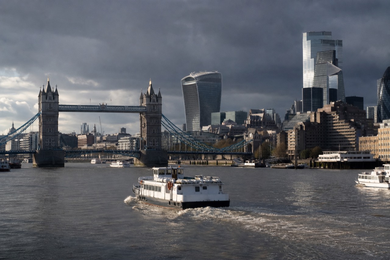 Several different boats on the Thames in central London with Tower Bridge behind