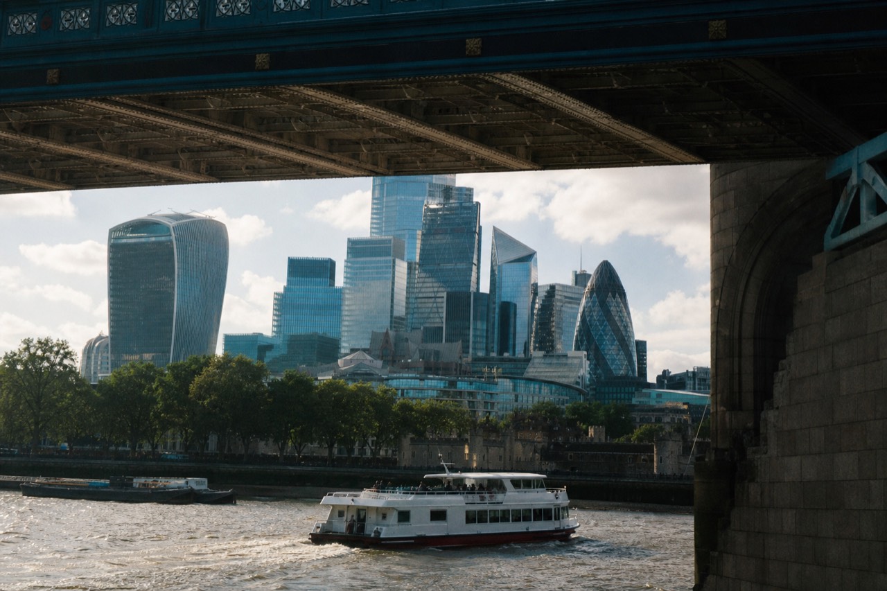 Sightseeing cruise boat on the Thames at dusk passing the lit Tower Bridge
